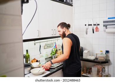 Young Hispanic Man Washing Dishes. Everyday Chores