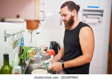 Young Hispanic Man Washing Dishes. Everyday Chores