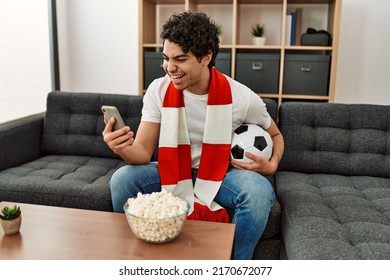 Young Hispanic Man Watching Soccer Match And Supporting Team At Home.