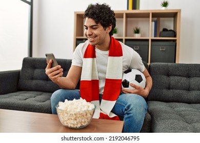 Young Hispanic Man Watching Soccer Match And Supporting Team At Home.