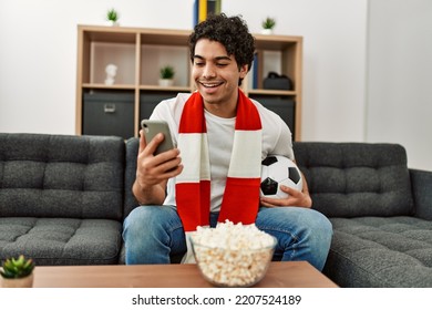 Young Hispanic Man Watching Soccer Match And Supporting Team At Home.