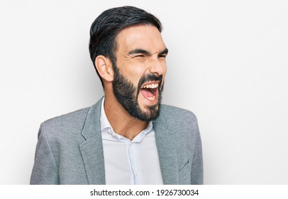 Young Hispanic Man Wearing Business Clothes Angry And Mad Screaming Frustrated And Furious, Shouting With Anger. Rage And Aggressive Concept. 