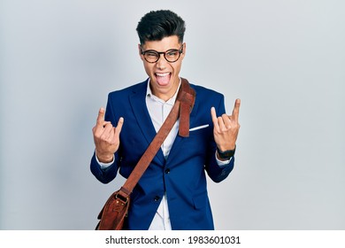 Young Hispanic Man Wearing Business Clothes Shouting With Crazy Expression Doing Rock Symbol With Hands Up. Music Star. Heavy Concept. 