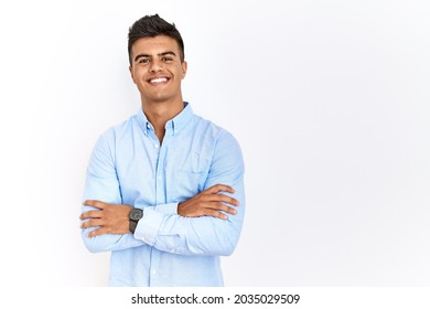 Young hispanic man wearing business shirt standing over isolated background happy face smiling with crossed arms looking at the camera. positive person.  - Powered by Shutterstock