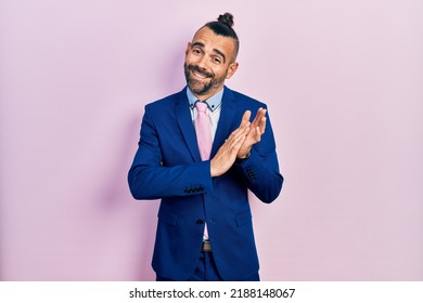 Young Hispanic Man Wearing Business Suit And Tie Clapping And Applauding Happy And Joyful, Smiling Proud Hands Together 