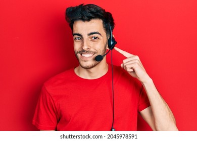 Young Hispanic Man Wearing Call Center Agent Headset Smiling Happy Pointing With Hand And Finger 