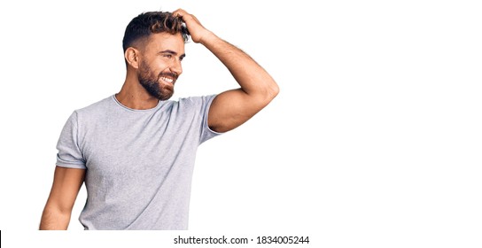 Young hispanic man wearing casual clothes smiling confident touching hair with hand up gesture, posing attractive and fashionable 
