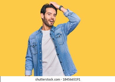 Young Hispanic Man Wearing Casual Clothes Smiling Confident Touching Hair With Hand Up Gesture, Posing Attractive And Fashionable 