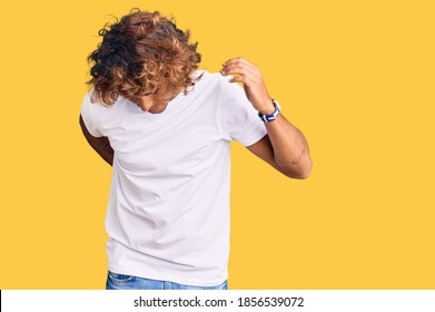 Young Hispanic Man Wearing Casual White Tshirt Suffering Of Backache, Touching Back With Hand, Muscular Pain 