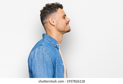 Young Hispanic Man Wearing Casual Clothes Looking To Side, Relax Profile Pose With Natural Face With Confident Smile. 