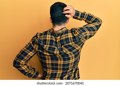 Young Hispanic Man Wearing Casual Clothes Backwards Thinking About Doubt With Hand On Head 