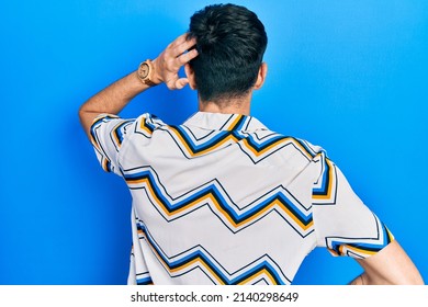 Young Hispanic Man Wearing Casual Clothes Backwards Thinking About Doubt With Hand On Head 