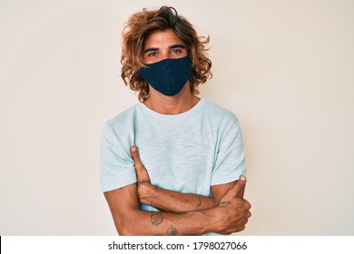 Young Hispanic Man Wearing Covid-19 Mask Happy Face Smiling With Crossed Arms Looking At The Camera. Positive Person. 