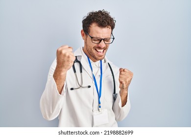 Young Hispanic Man Wearing Doctor Uniform And Stethoscope Very Happy And Excited Doing Winner Gesture With Arms Raised, Smiling And Screaming For Success. Celebration Concept. 