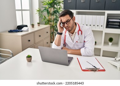 Young Hispanic Man Wearing Doctor Uniform Stressed Working At Clinic