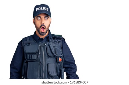 Young Hispanic Man Wearing Police Uniform Afraid And Shocked With Surprise And Amazed Expression, Fear And Excited Face. 