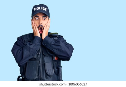 Young Hispanic Man Wearing Police Uniform Afraid And Shocked, Surprise And Amazed Expression With Hands On Face 