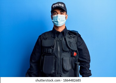 Young Hispanic Man Wearing Police Uniform And Medical Mask With A Happy And Cool Smile On Face. Lucky Person. 