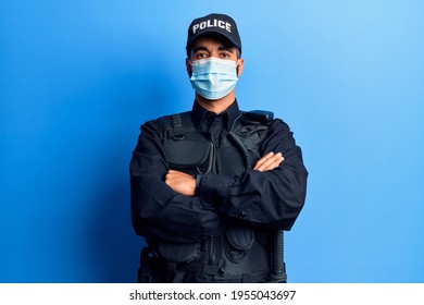 Young Hispanic Man Wearing Police Uniform And Medical Mask Happy Face Smiling With Crossed Arms Looking At The Camera. Positive Person. 