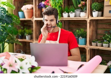 Young Hispanic Man Working At Florist Shop Doing Video Call Clueless And Confused With Open Arms, No Idea And Doubtful Face. 