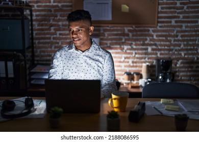 Young hispanic man working at the office at night looking to side, relax profile pose with natural face with confident smile.  - Shutterstock ID 2188086595