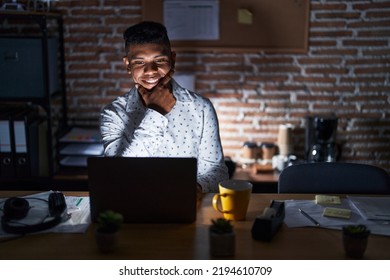 Young hispanic man working at the office at night looking confident at the camera smiling with crossed arms and hand raised on chin. thinking positive.  - Shutterstock ID 2194610709