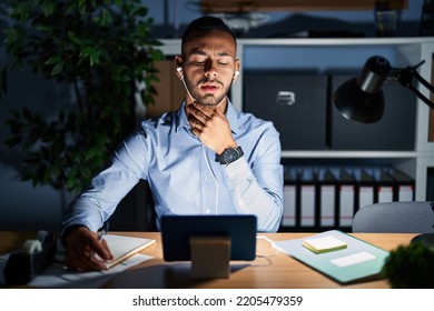 Young Hispanic Man Working At The Office At Night Touching Painful Neck, Sore Throat For Flu, Clod And Infection 