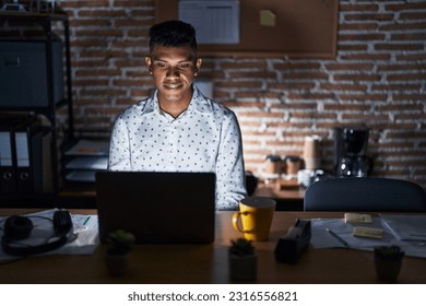 Young hispanic man working at the office at night with a happy and cool smile on face. lucky person.  - Shutterstock ID 2316556821
