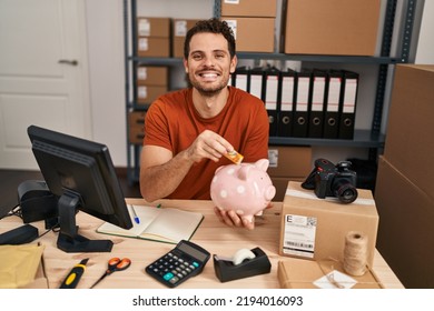 Young Hispanic Man Working At Small Business Ecommerce Holding Piggy Bank Smiling With A Happy And Cool Smile On Face. Showing Teeth. 