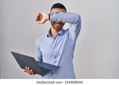 Young Hispanic Man Working Using Computer Laptop Smiling Cheerful Playing Peek A Boo With Hands Showing Face. Surprised And Exited 