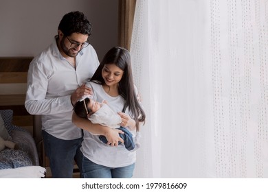 Young Hispanic Parents Holding Their Newborn Baby At Home- Parents In Love Taking Home Their Newborn Baby- Small Latin Family