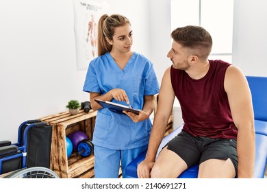 Young hispanic physioterapist woman explain diagnosis to patient man at the clinic. - Shutterstock ID 2140691271