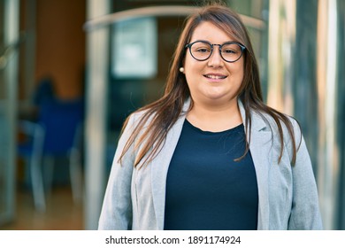 Young hispanic plus size businesswoman smiling happy standing at the city. - Powered by Shutterstock