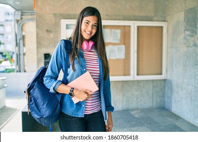 Young Hispanic Student Girl Smiling Happy Using Headphones At The University.