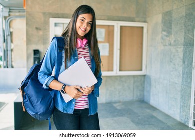 Young Hispanic Student Girl Smiling Happy Holding Laptop At The City.