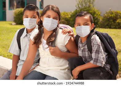 Young Hispanic Students on School Campus Wearing Medical Face Masks.