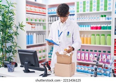 Young Hispanic Teenager Pharmacist Using Touchpad Holding Pills At Pharmacy