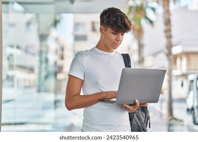 Young hispanic teenager student using laptop with relaxed expression at university - Powered by Shutterstock