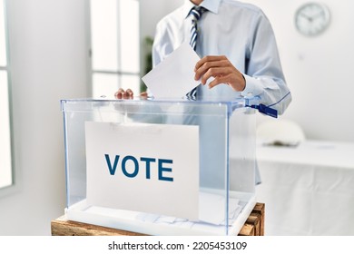 Young Hispanic Voter Man Putting Vote In Ballot At Electoral College.