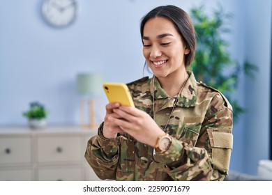 Young hispanic woman army soldier using smartphone at home - Powered by Shutterstock