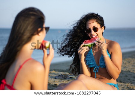 Young hispanic woman in bikini having fun on island summer holidays eating watermelon on beach