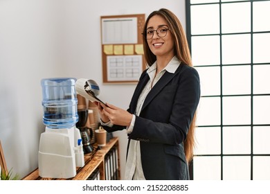 Young hispanic woman business worker reading paperwork working at office