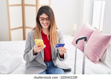 Young Hispanic Woman Business Worker Using Smartphone And Credit Card At Hotel Room