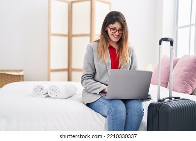 Young Hispanic Woman Business Worker Using Laptop Sitting On Bed At Hotel Room