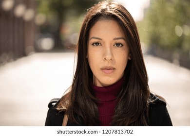 Young Hispanic Woman In City Serious Face