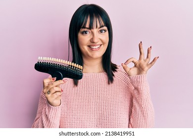 Young hispanic woman comparing teeth whitening doing ok sign with fingers, smiling friendly gesturing excellent symbol  - Shutterstock ID 2138419951