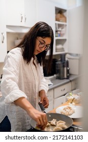 Young Hispanic Woman Cooking Dumplings In Her Home