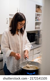 Young Hispanic Woman Cooking Dumplings In Her Home