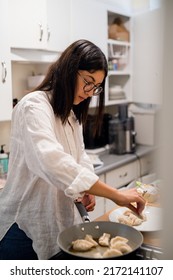 Young Hispanic Woman Cooking Dumplings In Her Home