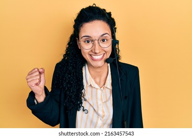 Young Hispanic Woman With Curly Hair Wearing Call Center Agent Headset Screaming Proud, Celebrating Victory And Success Very Excited With Raised Arm 